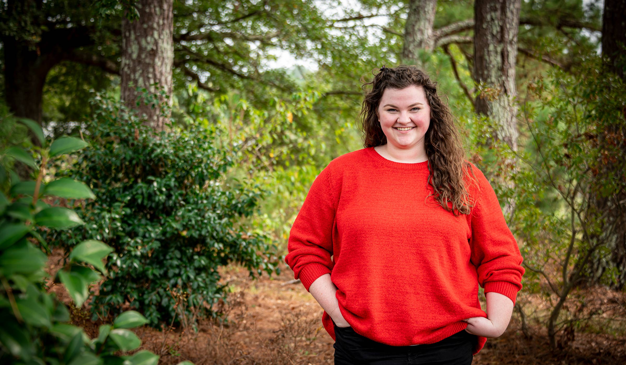 Reagan Poston, pictured outdoors in a woods setting.