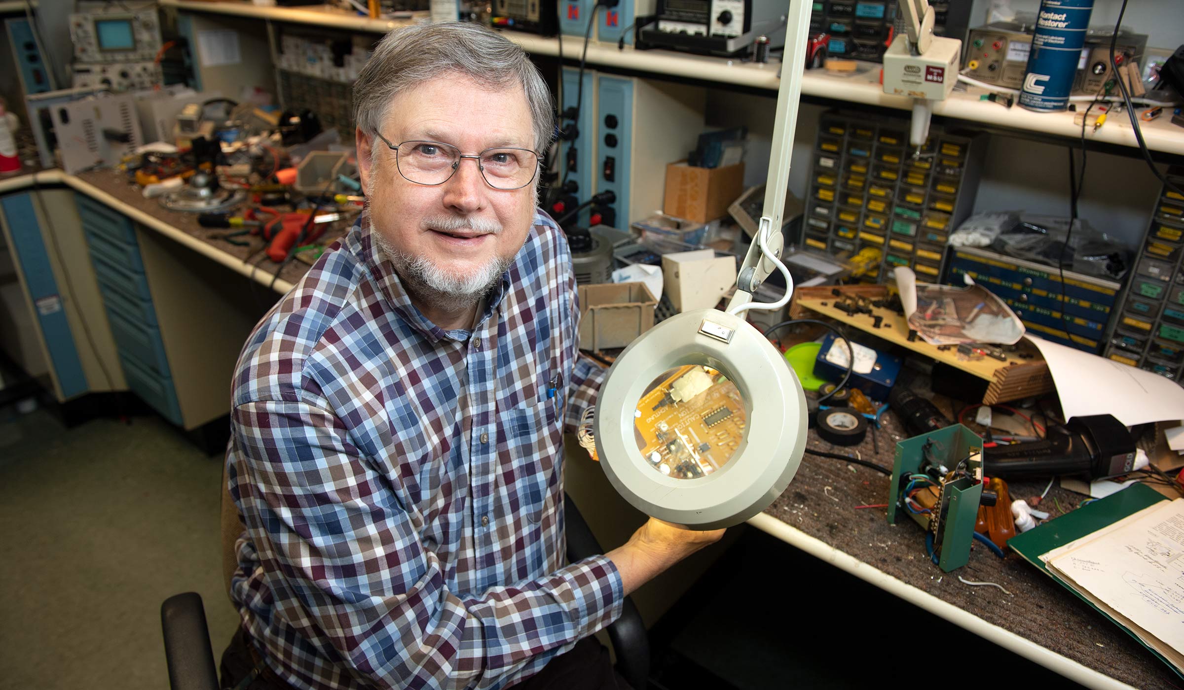 Ben Ardahl, pictured holding lab equipment in a workspace.