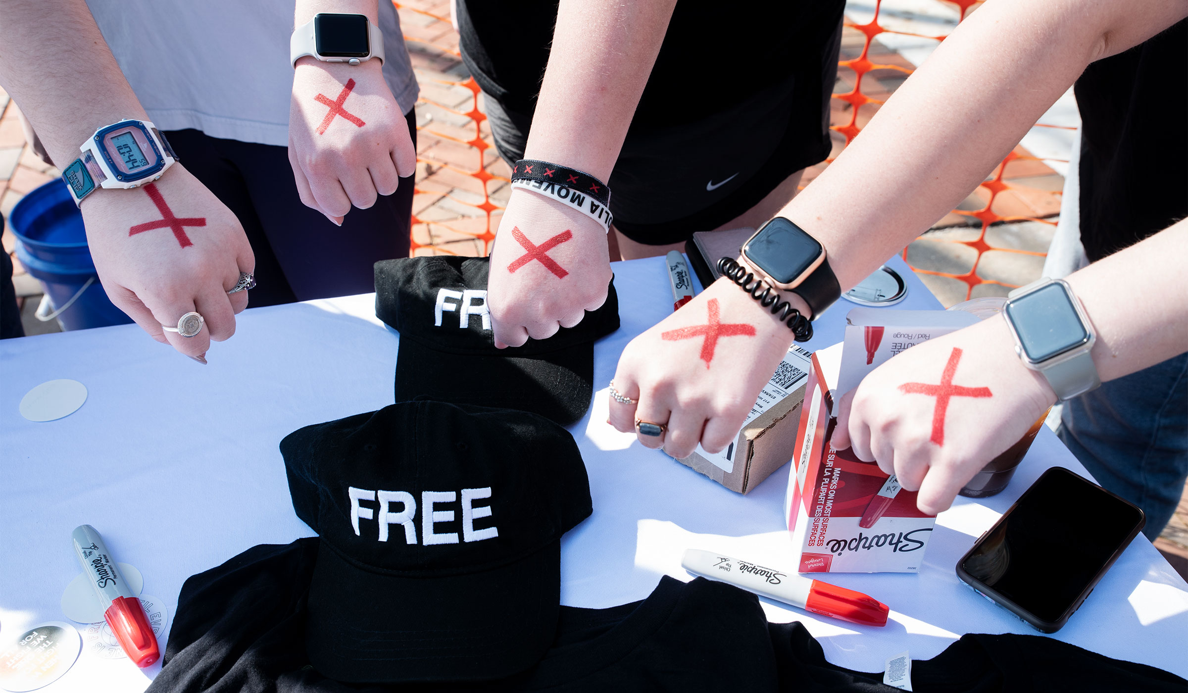 An array of hands with red &quot;X&quot; marks on them, displayed by members of the &quot;No Longer Bound&quot; student organization.