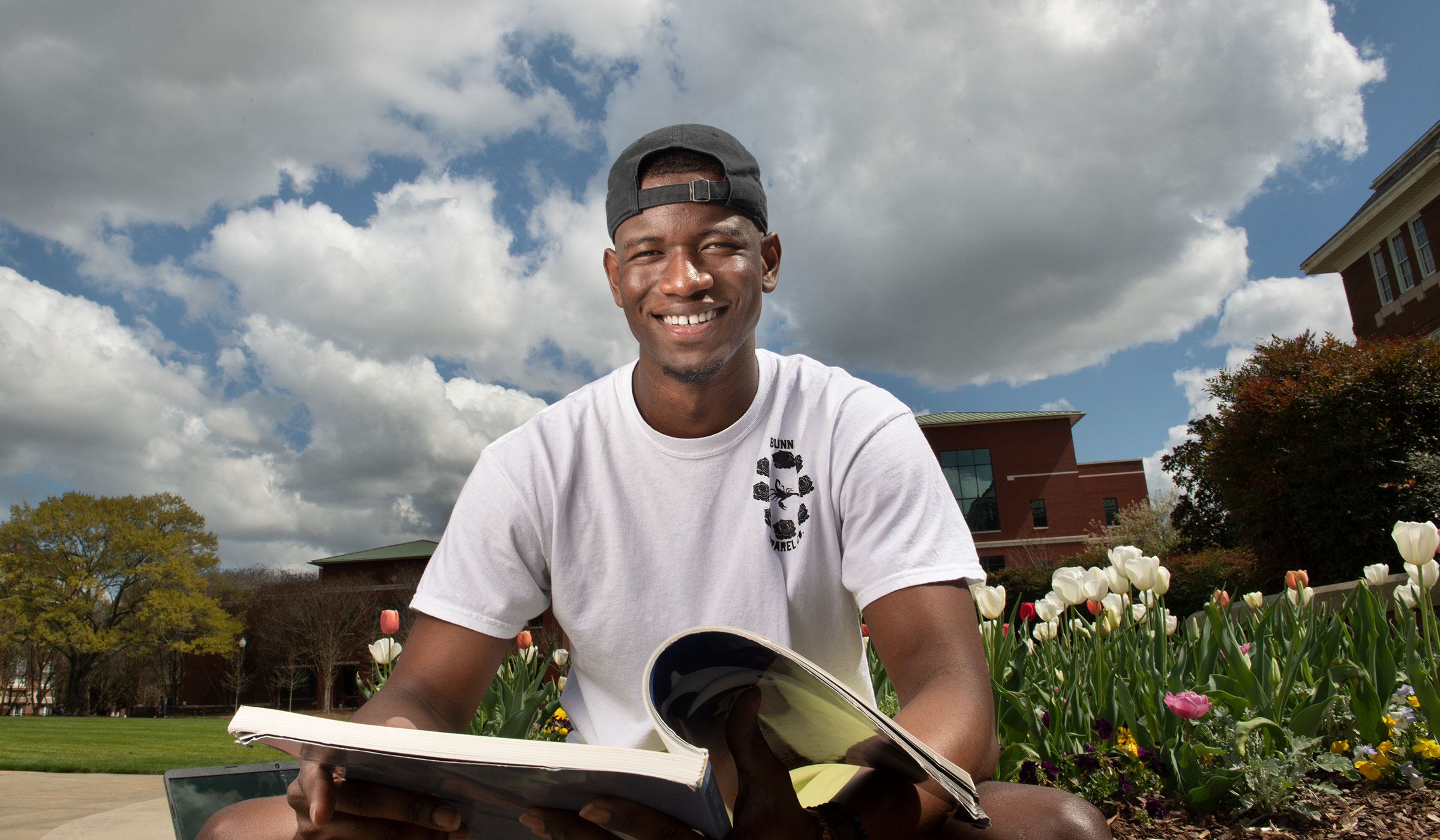 Asishana Amunega-Ajayi, pictured outside with a book on the MSU campus.