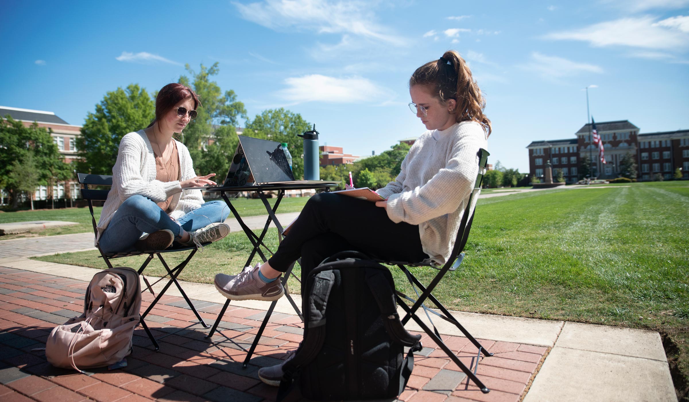 Students Erin Robbins and Maggie Moore studying outside before finals week.