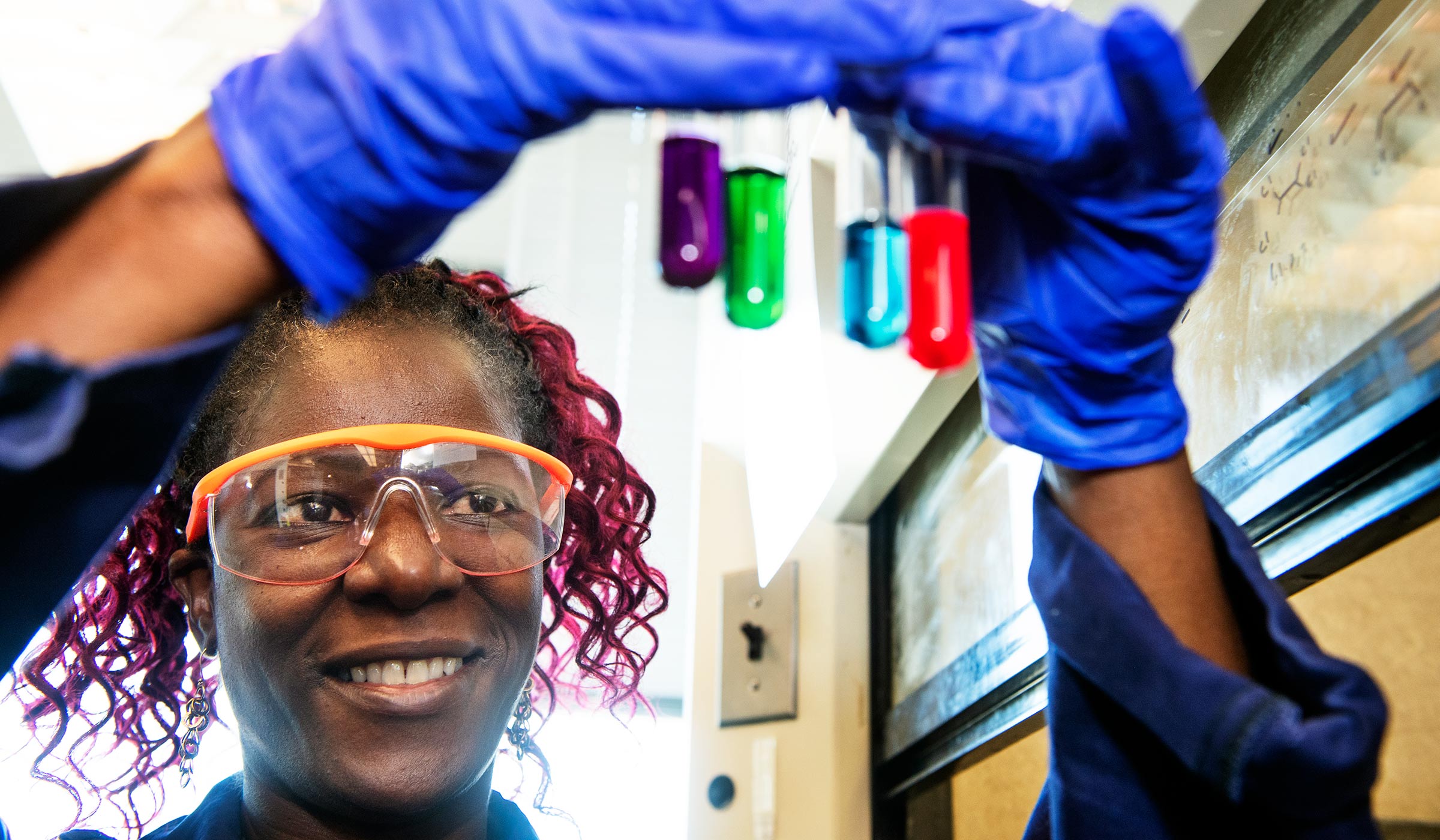 Collen Scott, pictured holding tubes in a chemistry lab.