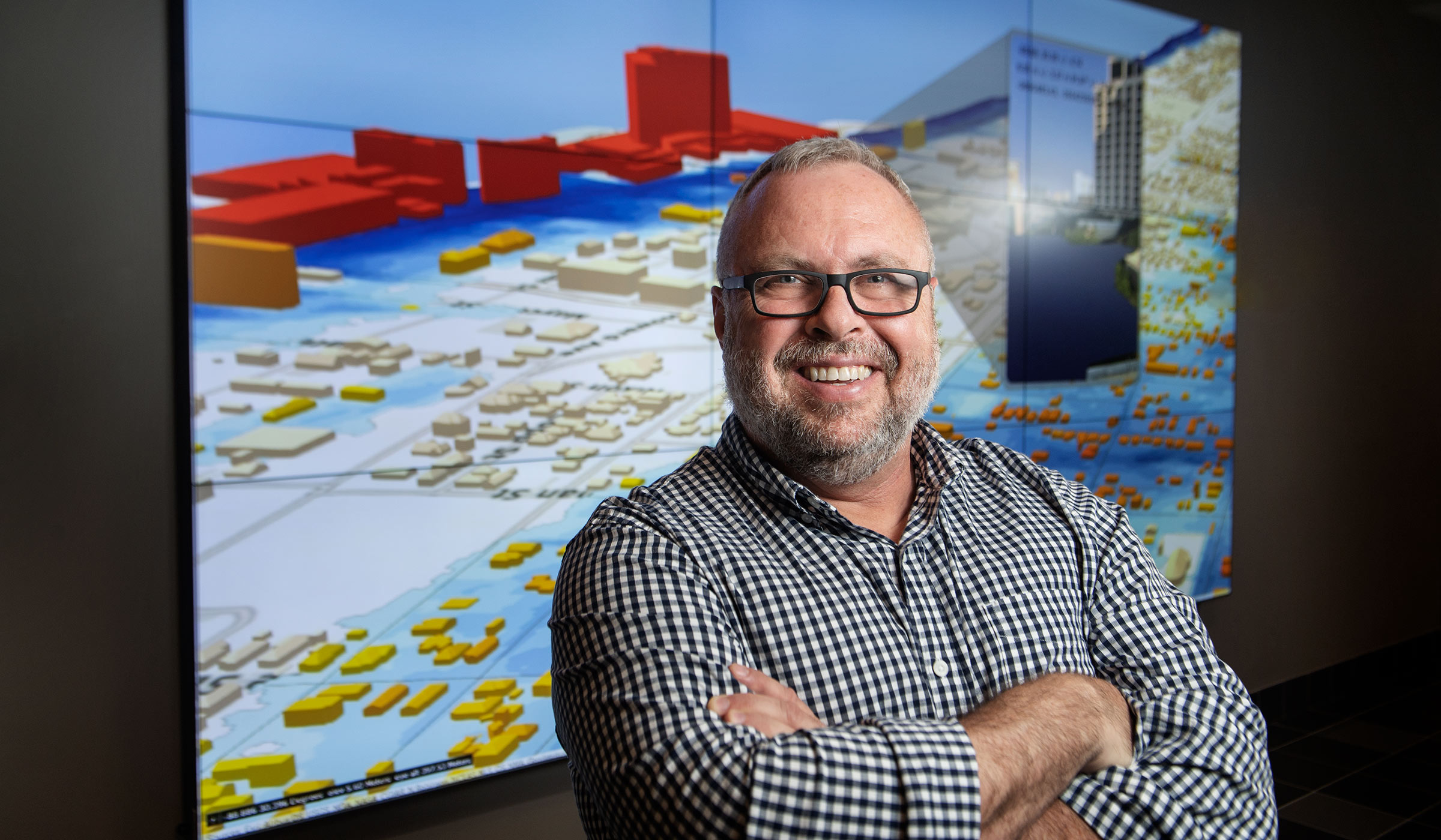 John Cartwright, pictured in front of computer visualizations.