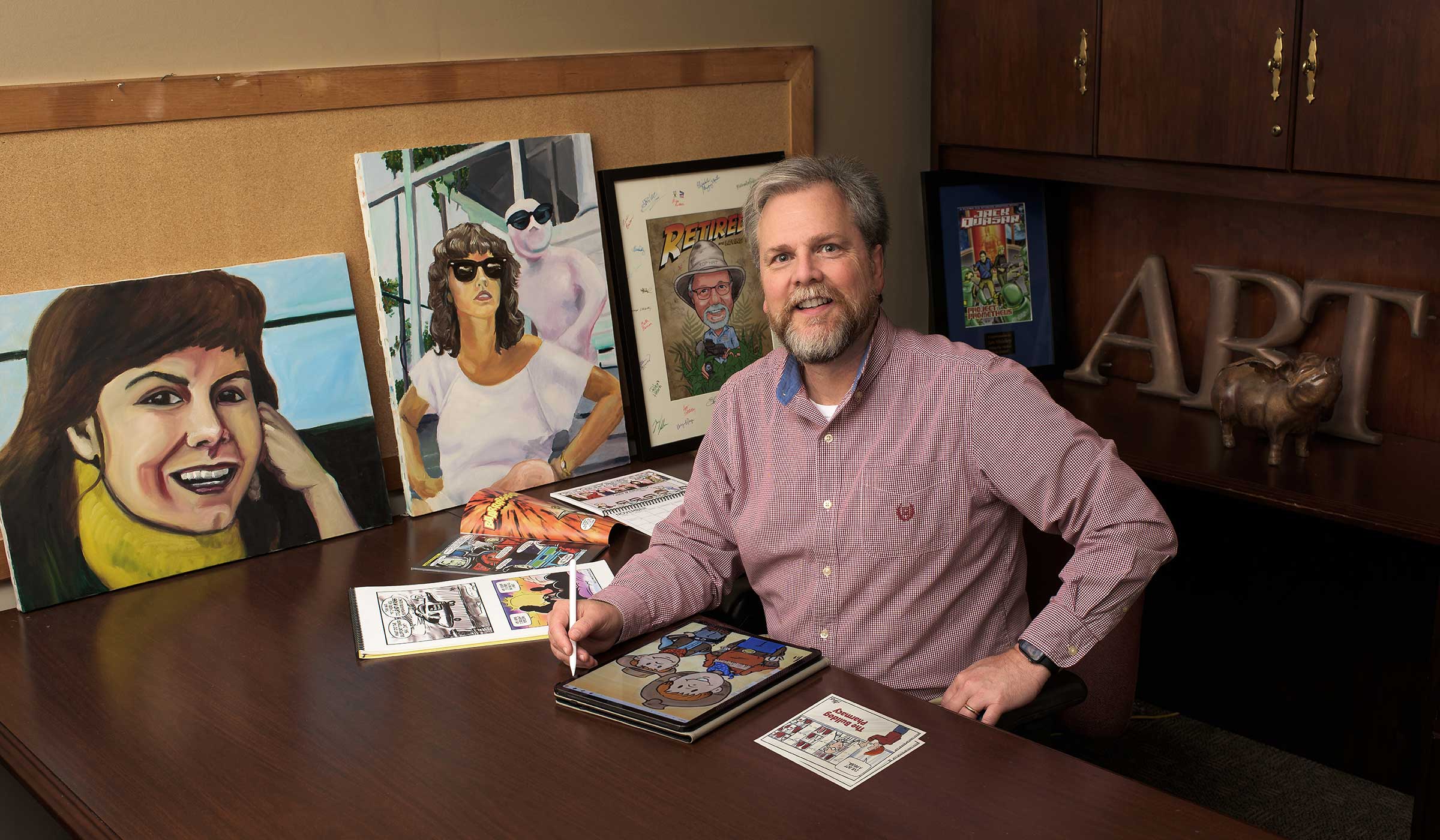 Art Shirley, pictured at his desk with his artwork.