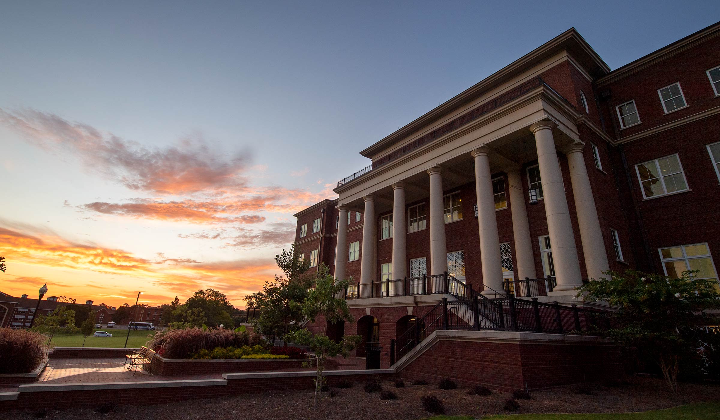 Sunrise near a red brick building with tan columns