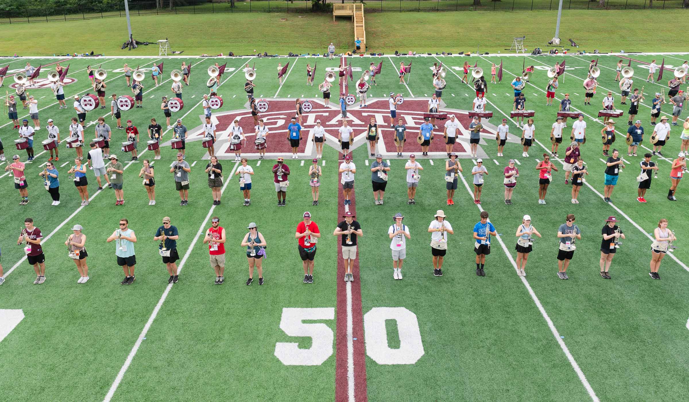 Marching band member stand0 in formation on the practice field