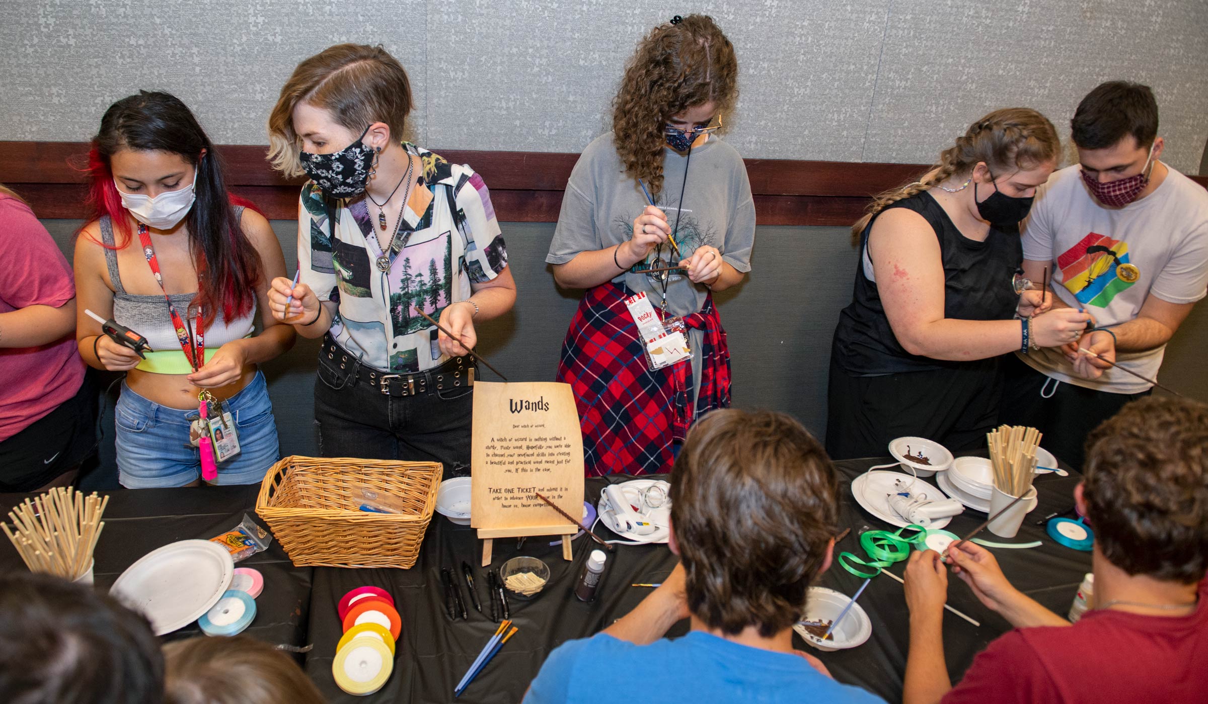 Students (wearing masks as a Covid precaution) work on painting their wands at one of the activity stations in the Hogwarts event in the Union.