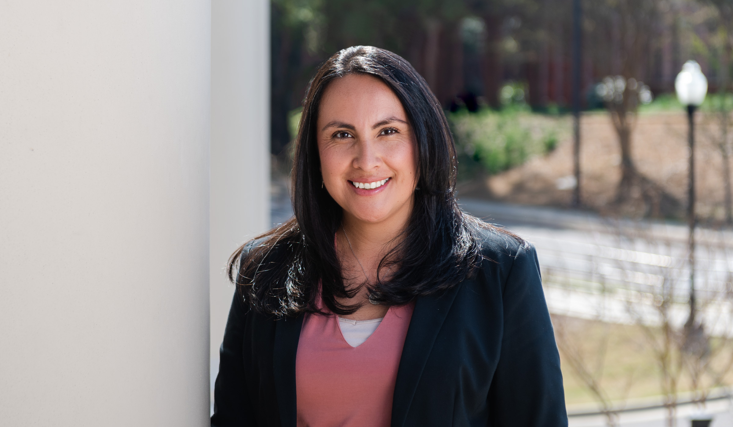 Gina Rico Méndez, pictured next to a white column at the Social Science Research Center