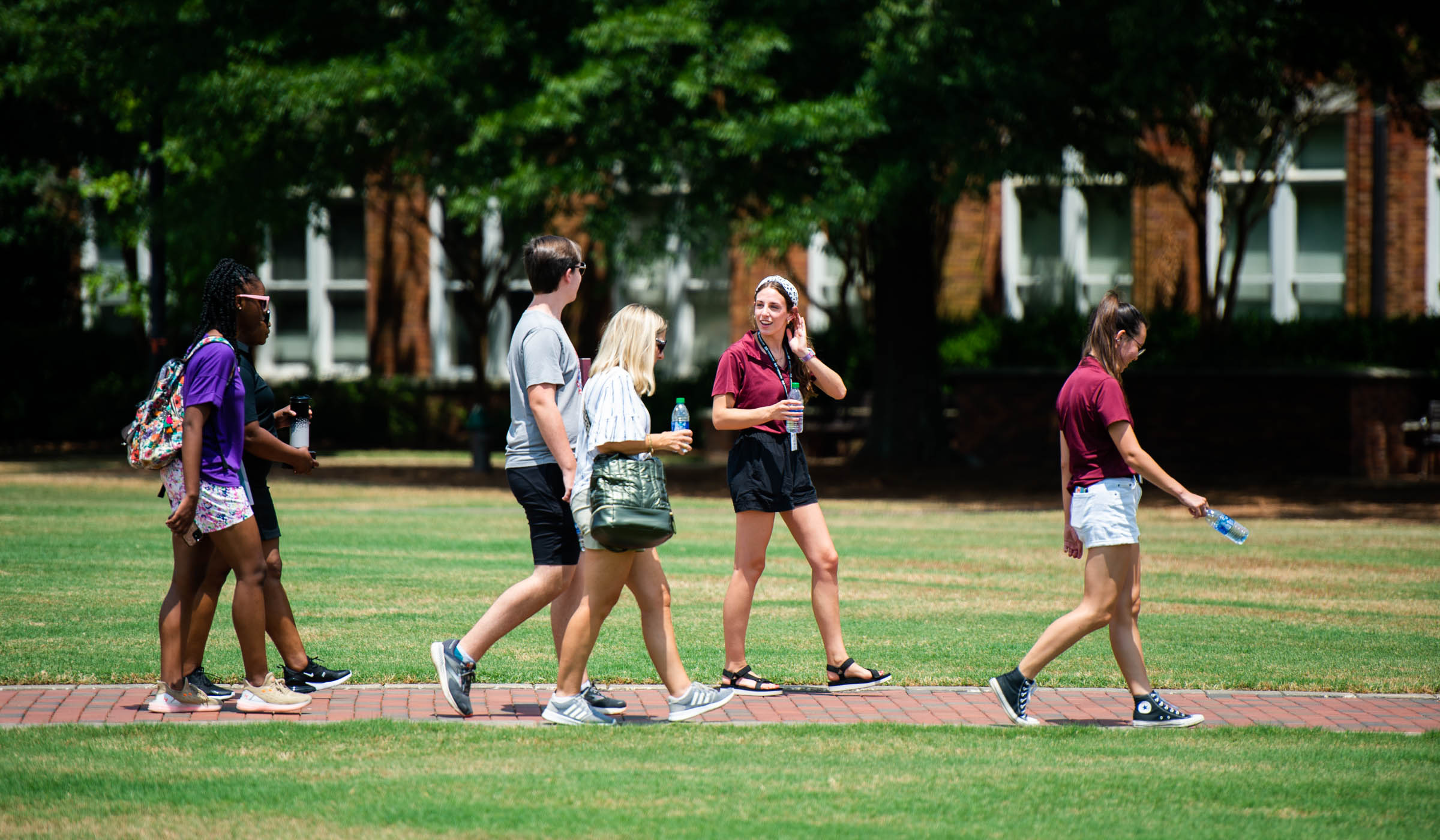 MSU roadrunner Lauren Weaks leads a guided walking group tour for 4 incoming students across the Drill Field.