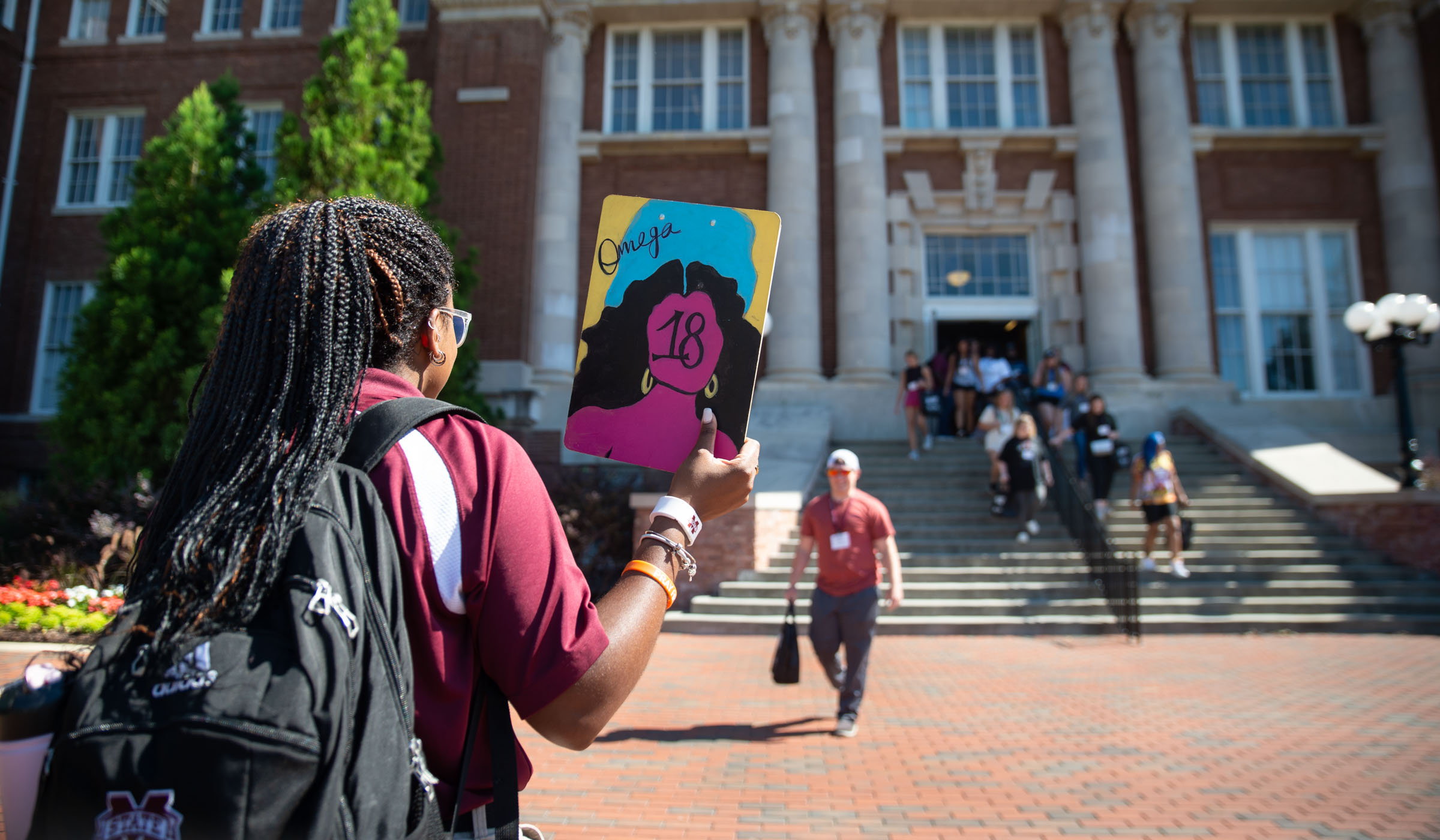 Orientation Leader Omega Storey holds up her #19 clipboard to summon the freshmen in her Orientation group as they come down the stairs of Lee Hall.