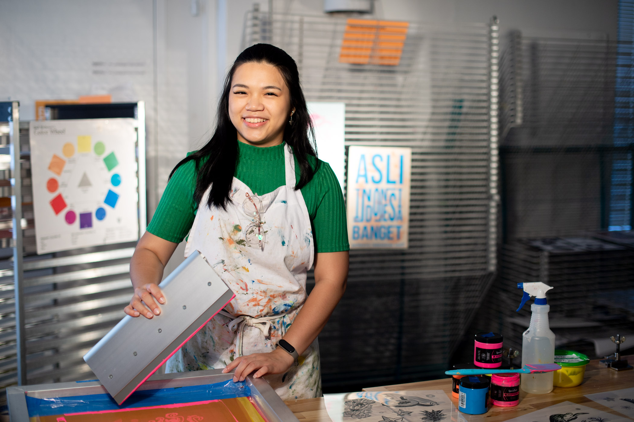 Trisha Harjono, pictured in an art studio with colorful paint.