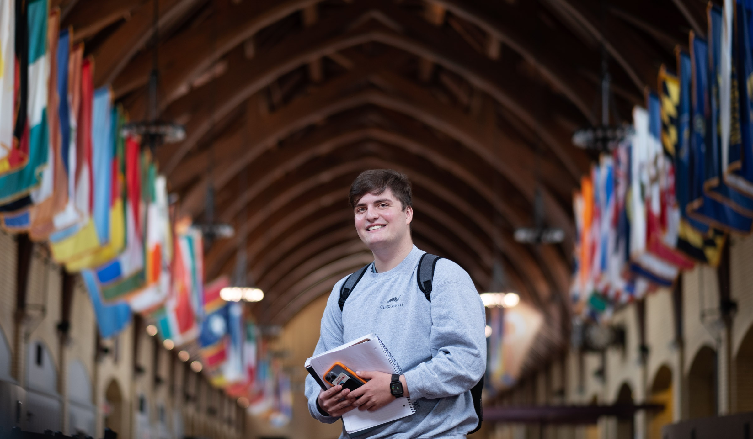 Sam Stewart, pictured standing in front of the world&#039;s flags at Perry Cafeteria