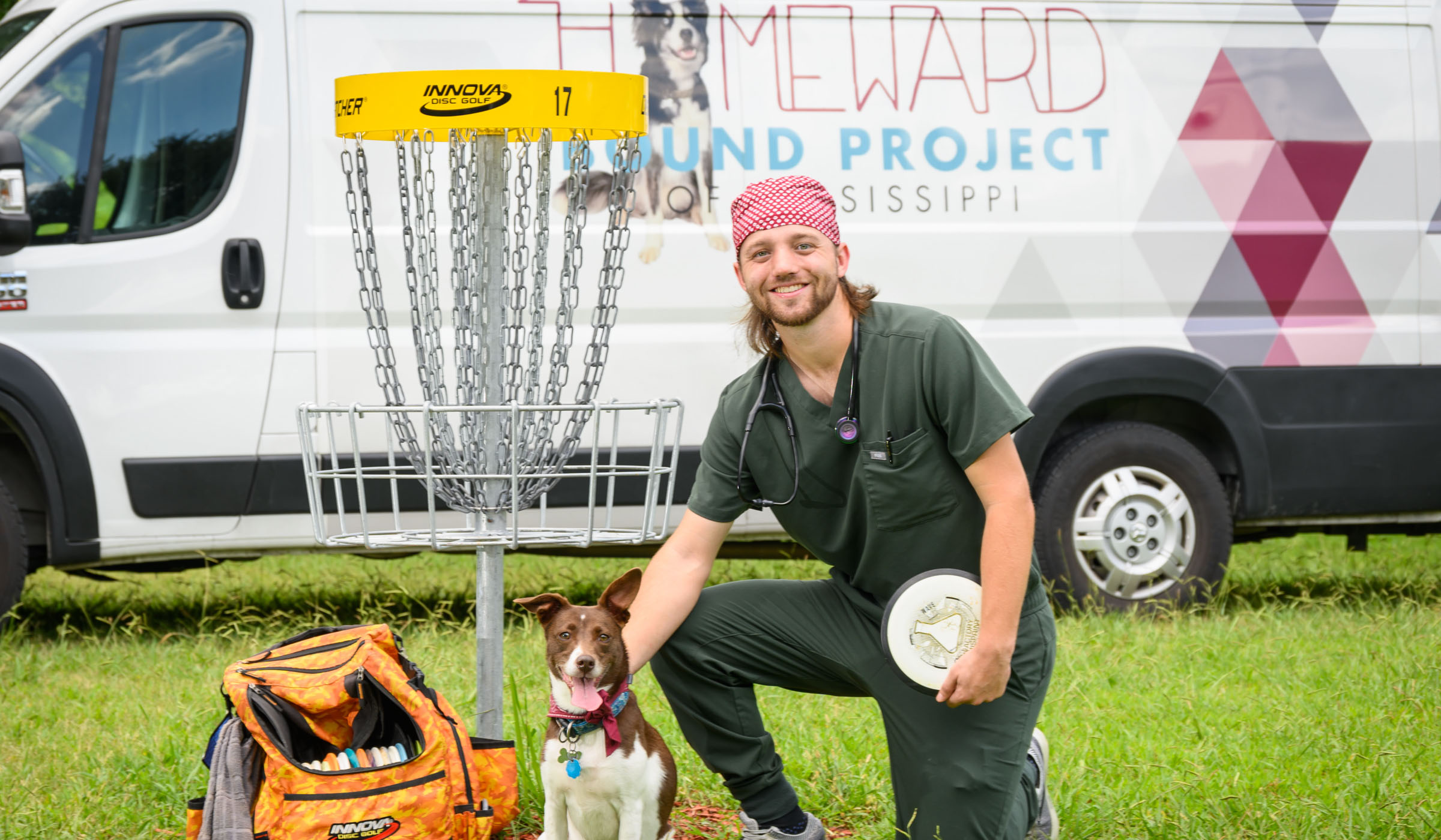 Ian Evans, pictured in front of a disc golf set, dog and van.
