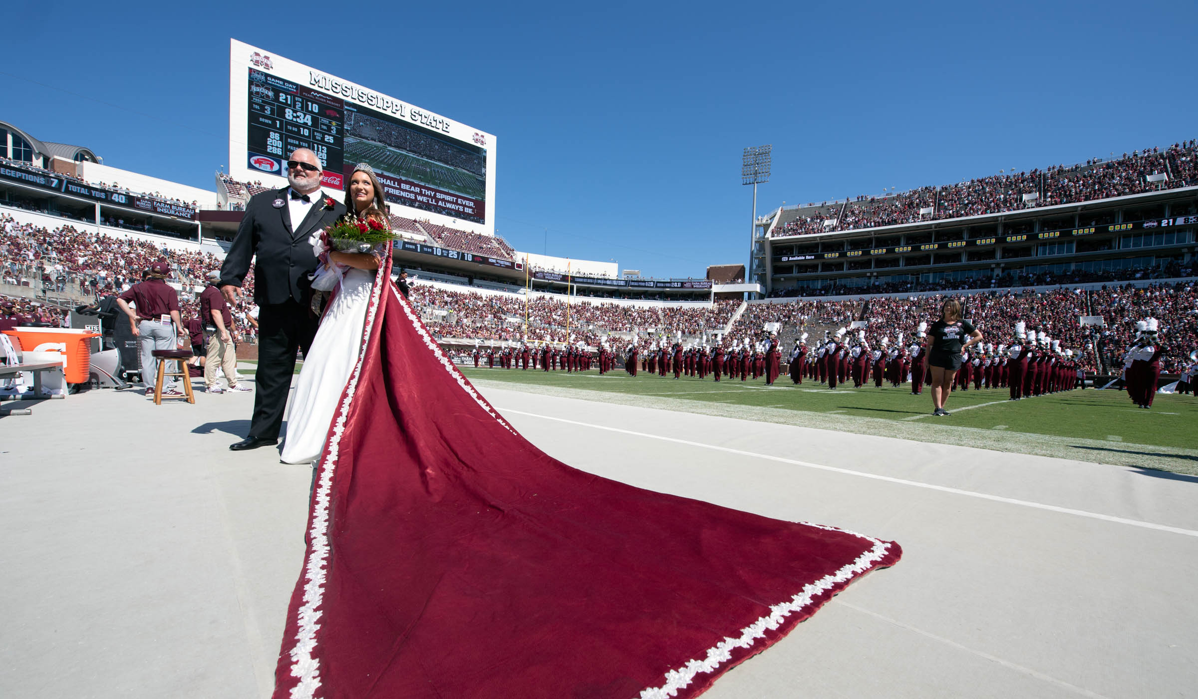 Homecome Queen Raegan Rushing and her father listen to MSU&#039;s alma mater on the sidelines at the conclusion of the Homecoming Court Halftime show.