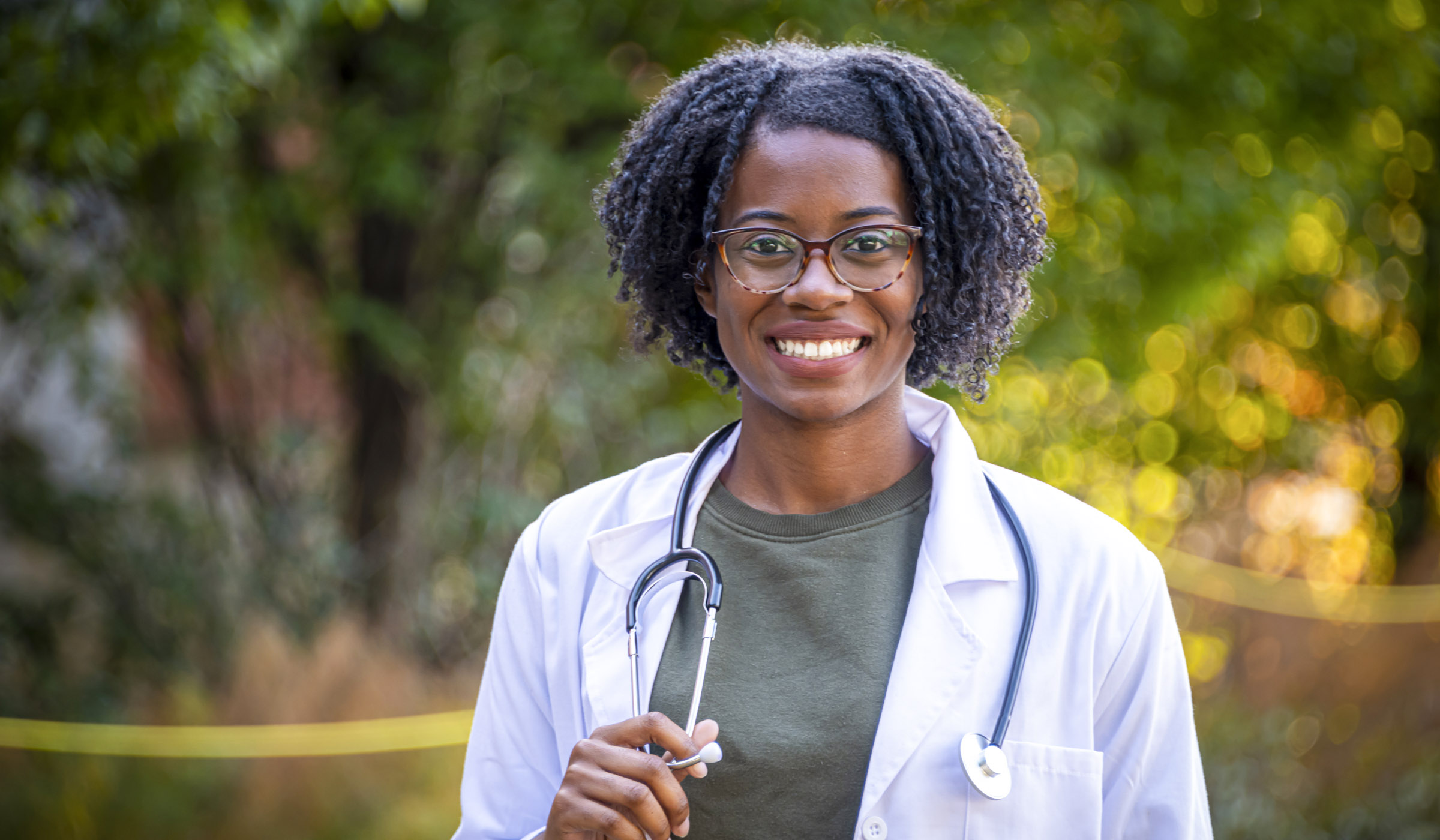 Marimba Williams, pictured in a lab coat outside and holding a stethoscope.