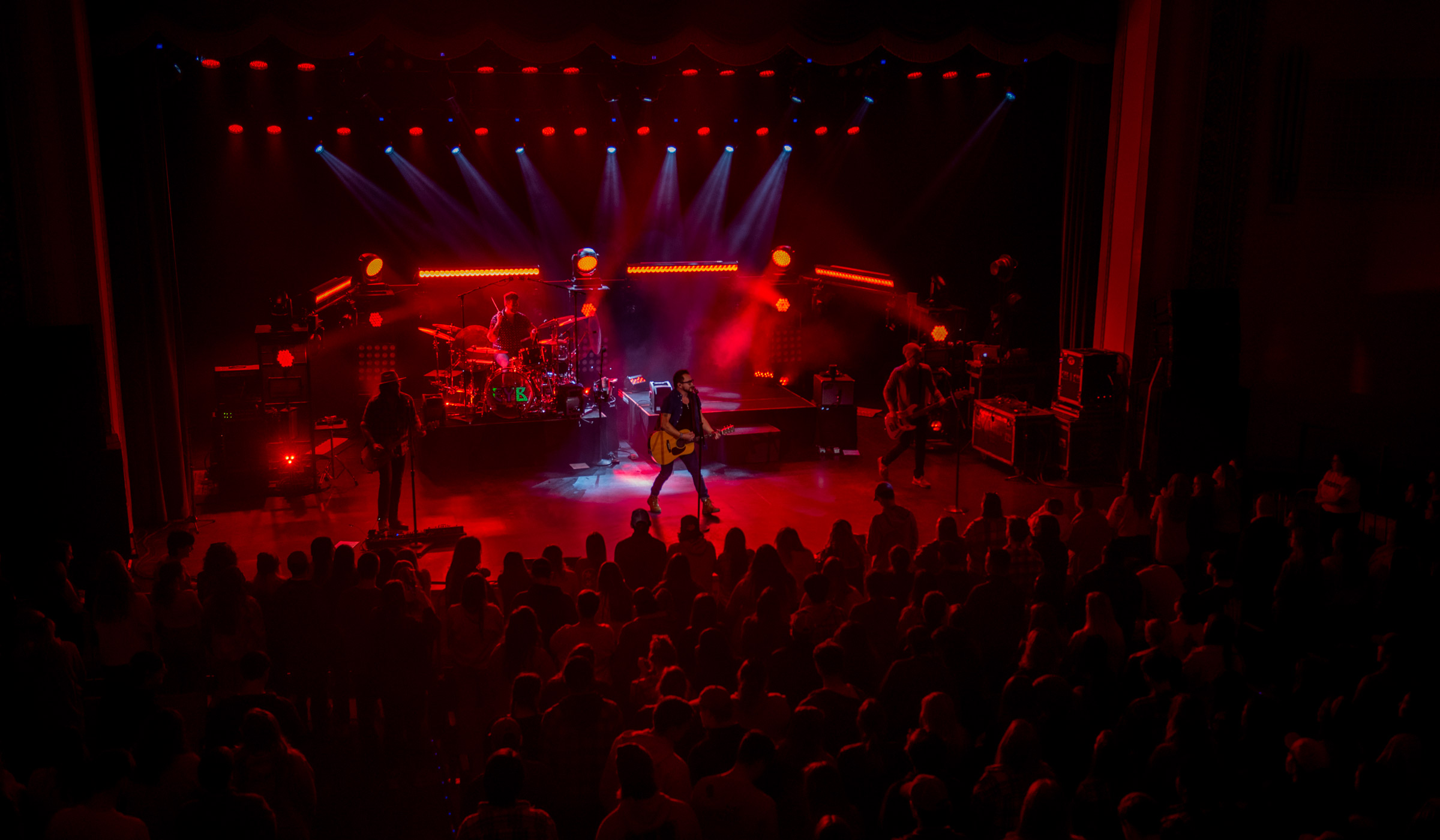 Viewed from above, the Bettersworth stage glows red with the Eli Young Band performing and audience heads in silhouette.