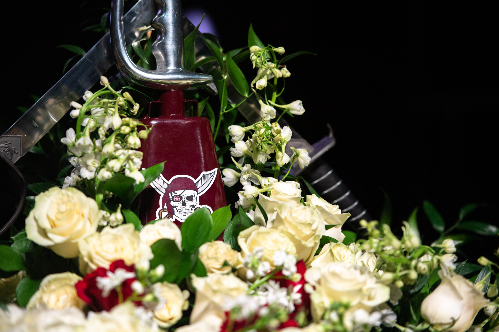 Flowers surround a Jolly Roger cowbell in honor of the infamous &quot;Pirate,&quot; Mike Leach