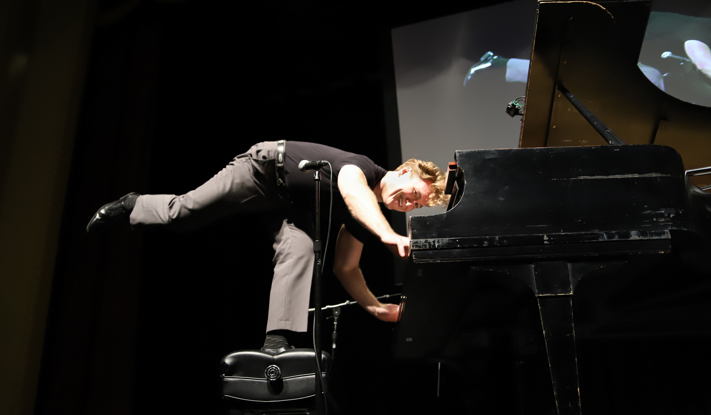 Standing on one leg on the piano bench while playing, Bennett performs his Jerry Lee Lewis act.