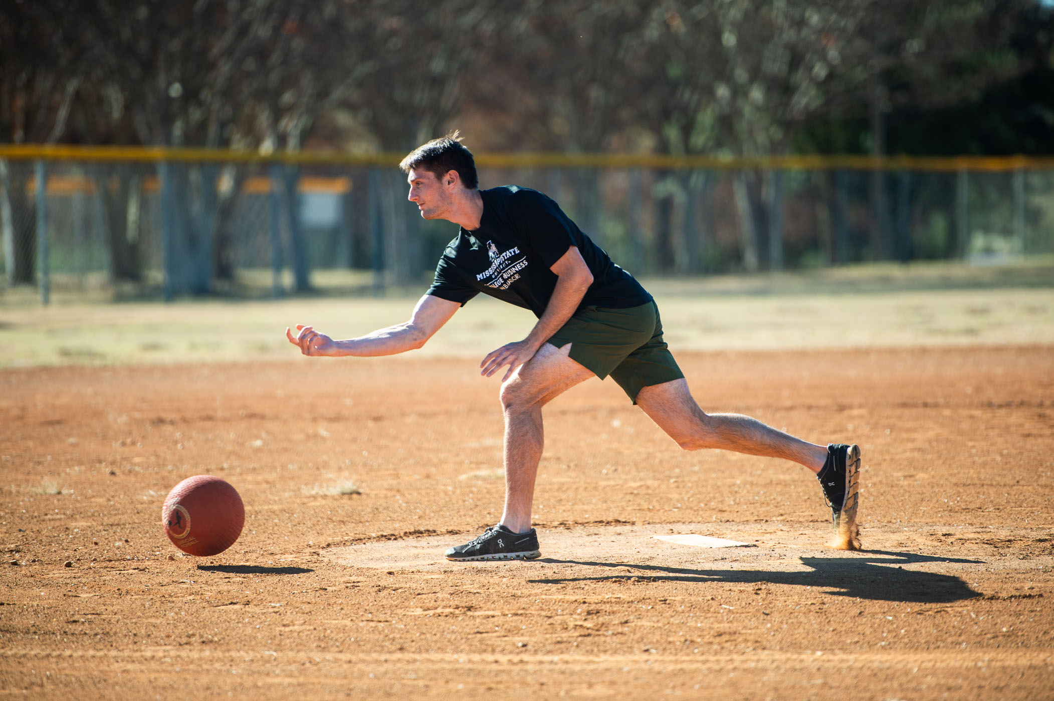 Noah Carpenter, a sophomore representing MSU&#039;s College of Business student ambassador team, sends a pitch to home plate.