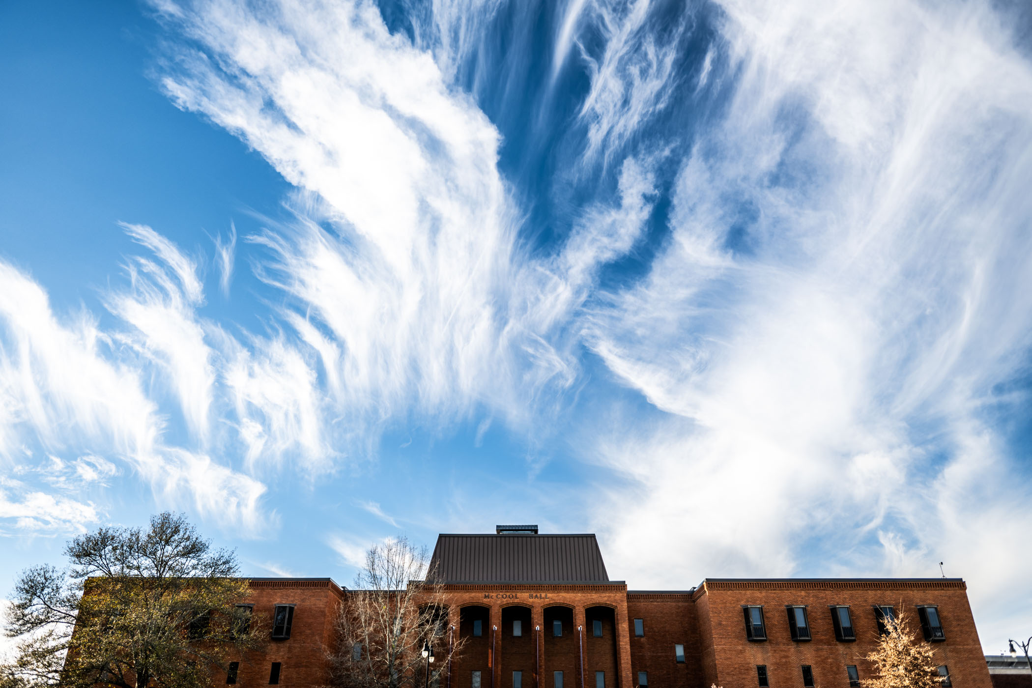 Wispy Cirrus clouds crown the sky above McCool Hall on a bright winter afternoon