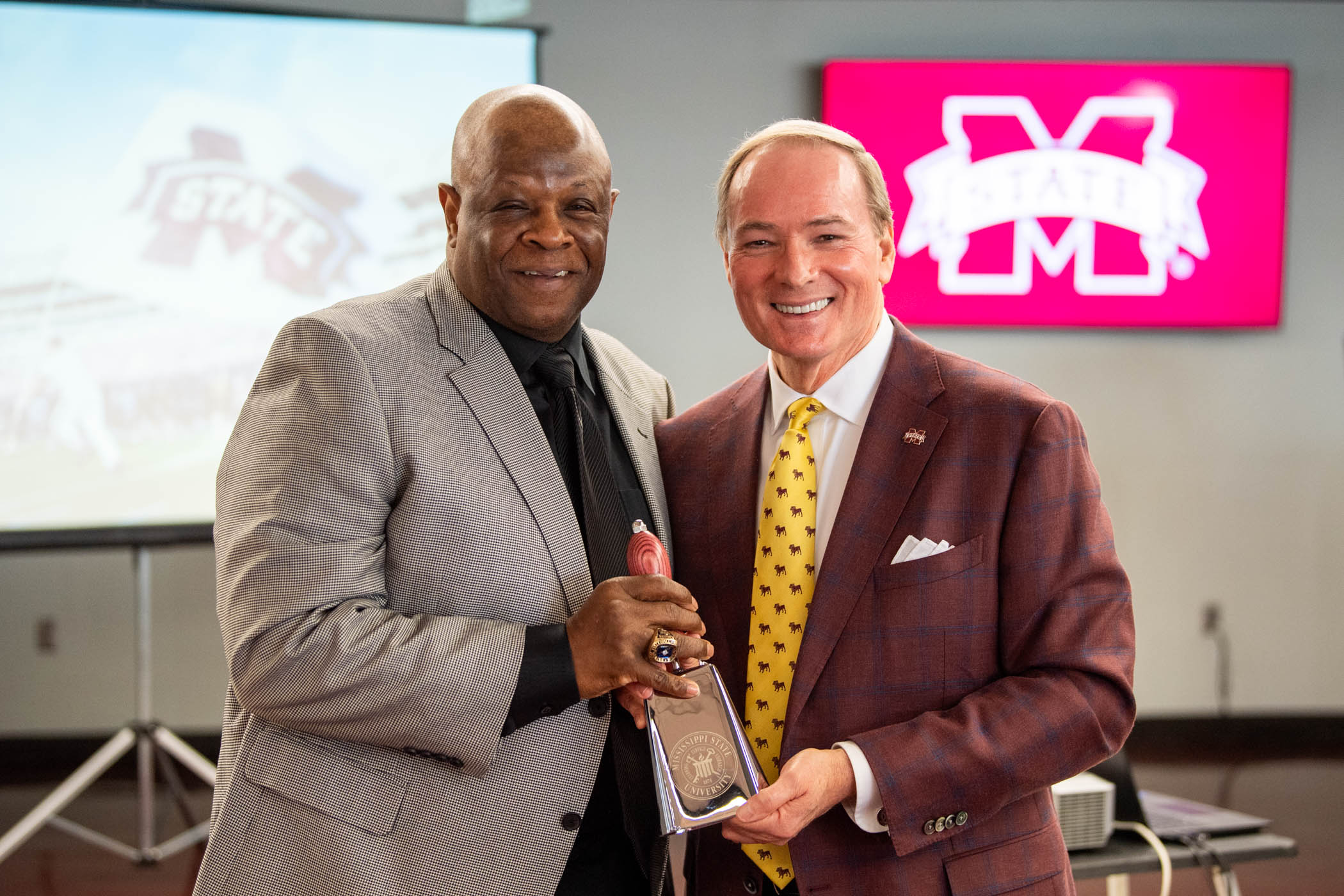 MSU President Mark E. Keenum presents a cowbell to Sylvester Croom