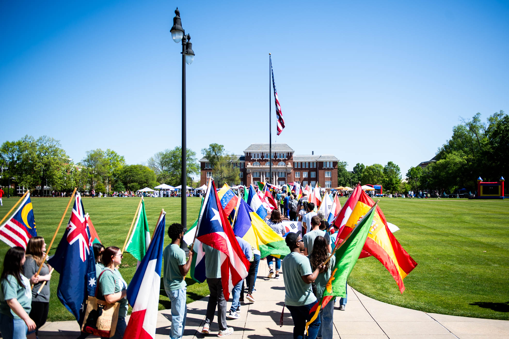 MSU community members march vibrant flags of countries around the world through the center of the Drill Field to kick off the start of International Fiesta 2024.