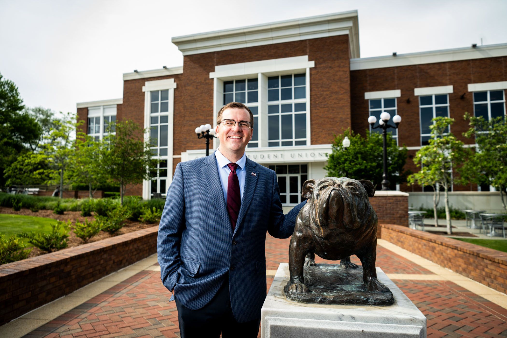 man standing with bully statue