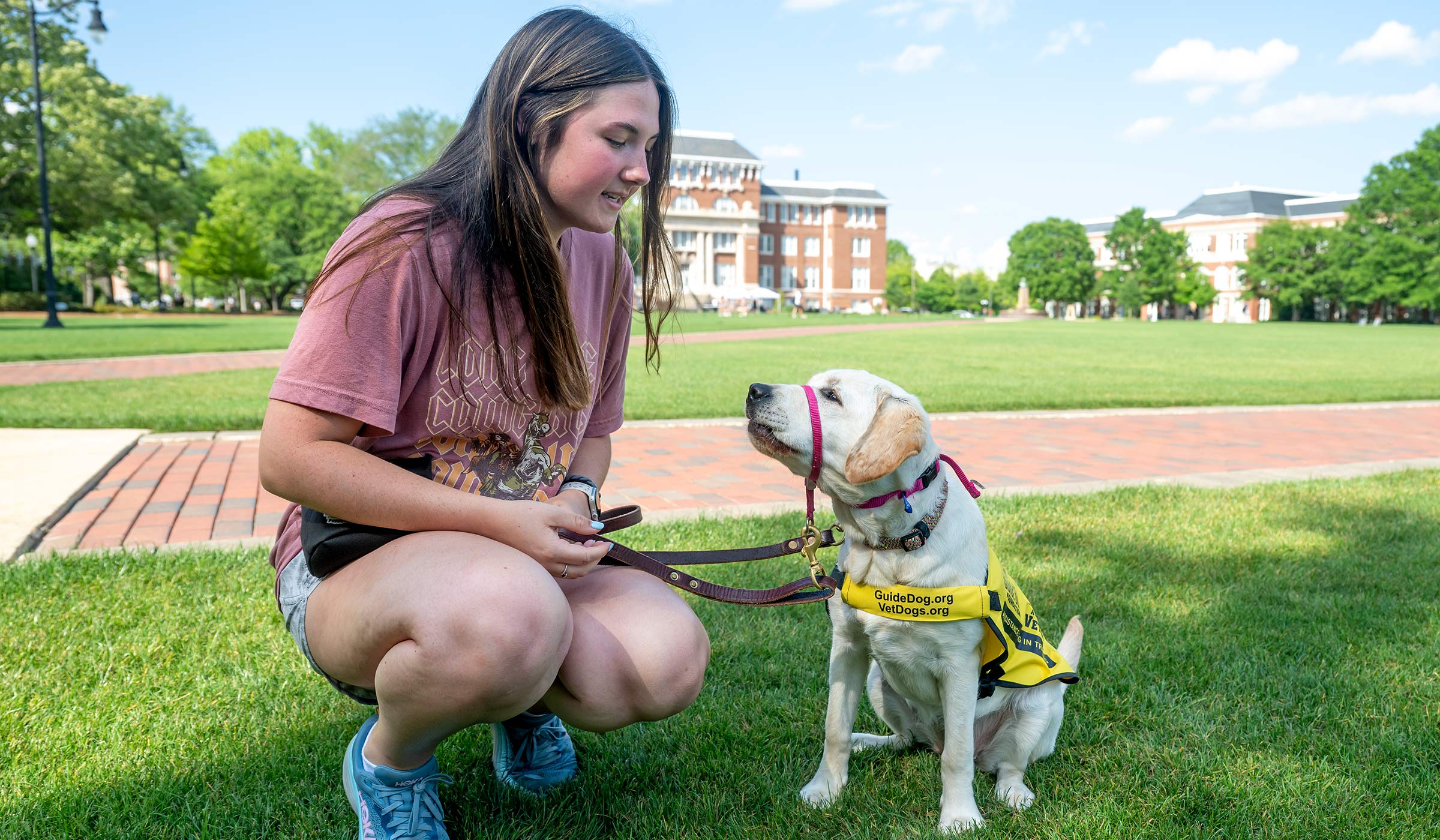 Puppy-raiser and puppy, part of the organization Puppies with a Purpose, on the Drill Field