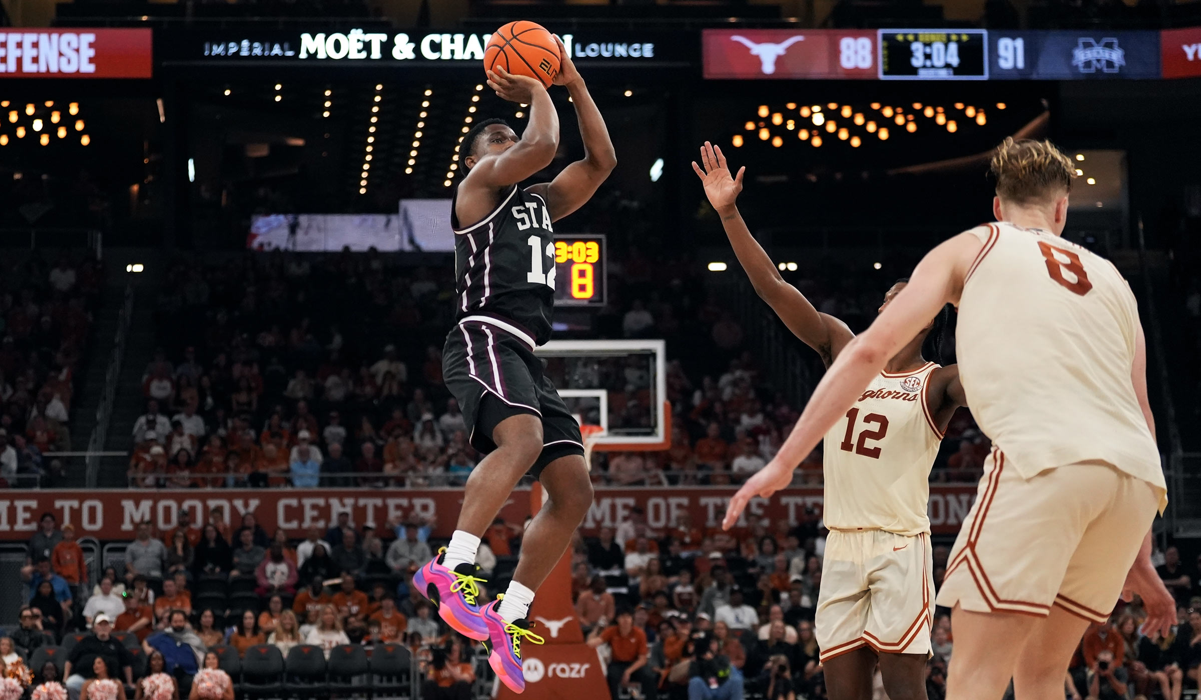 Guy in black basketball uniform going up for a shot
