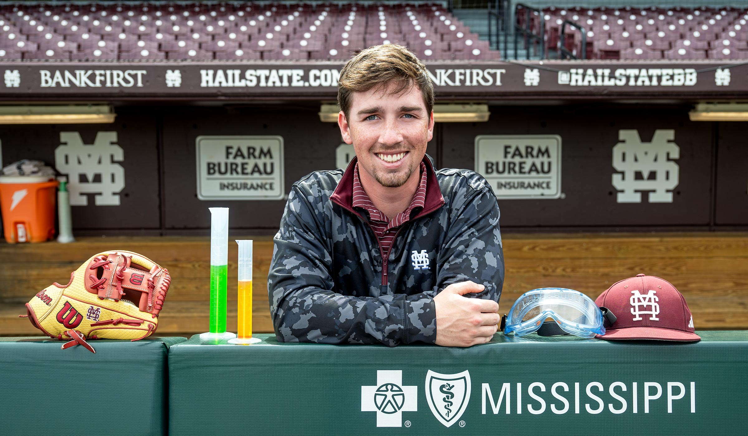 young man at baseball stadium with beakers
