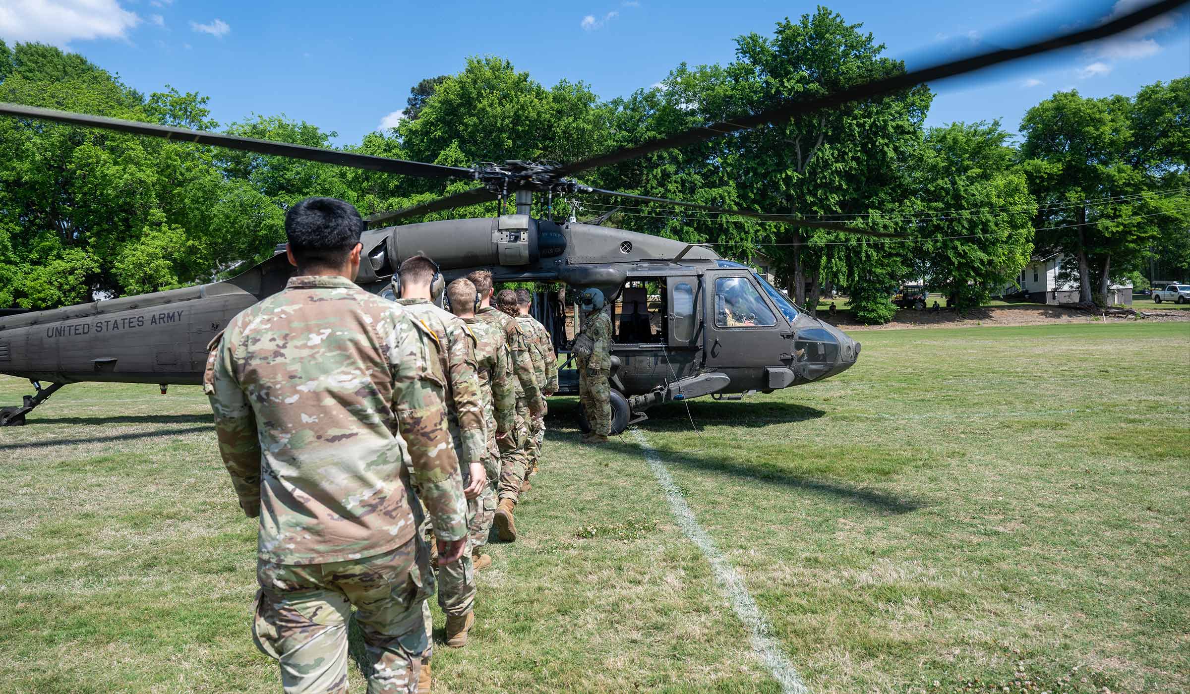 Army ROTC cadets line up to board a Black Hawk helicopter.