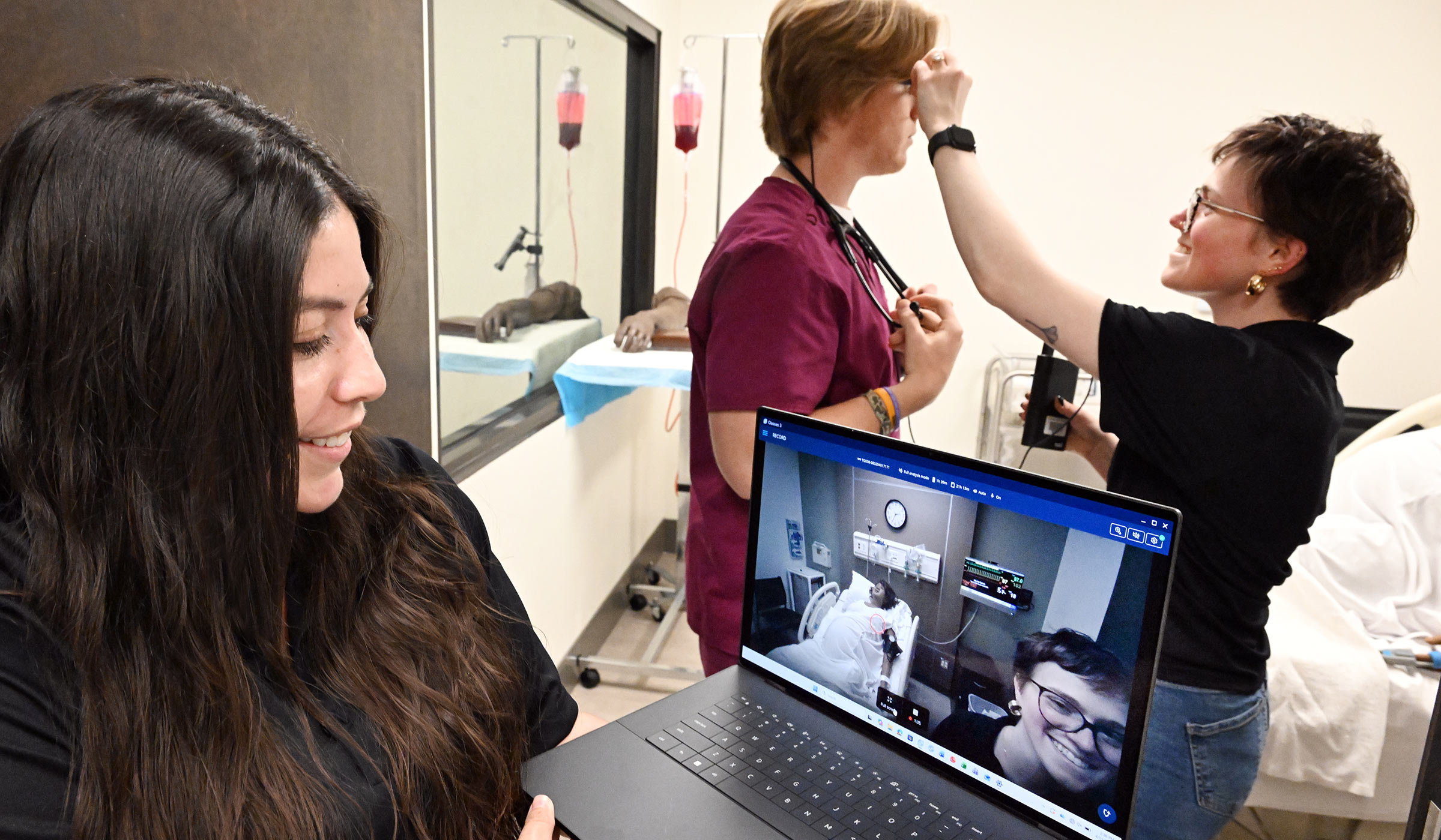 Nursing students test eye-tracking glasses while observing a laptop before a labor-and-delivery simulation.