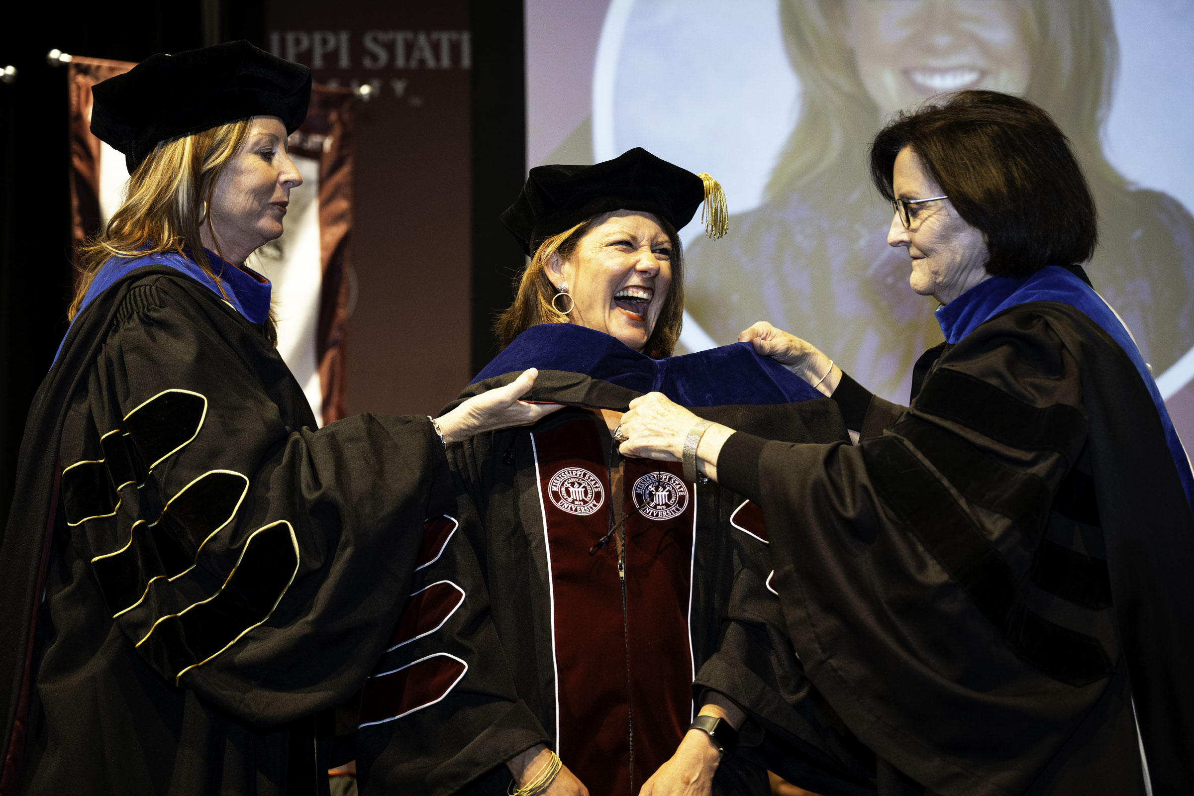 Krista Nicholson, a PhD candidate in MSU's College of Education, is hooded by Dean Teresa Jayroe and Associate Clinical Professor in the Department of Educational Leadership Leigh Ann McMullin at the spring 2026 Doctoral Commencement and Hooding Ceremony. The program, hosted by MSU's Graduate School, is one of six commencement events held at the Starkville campus this week.