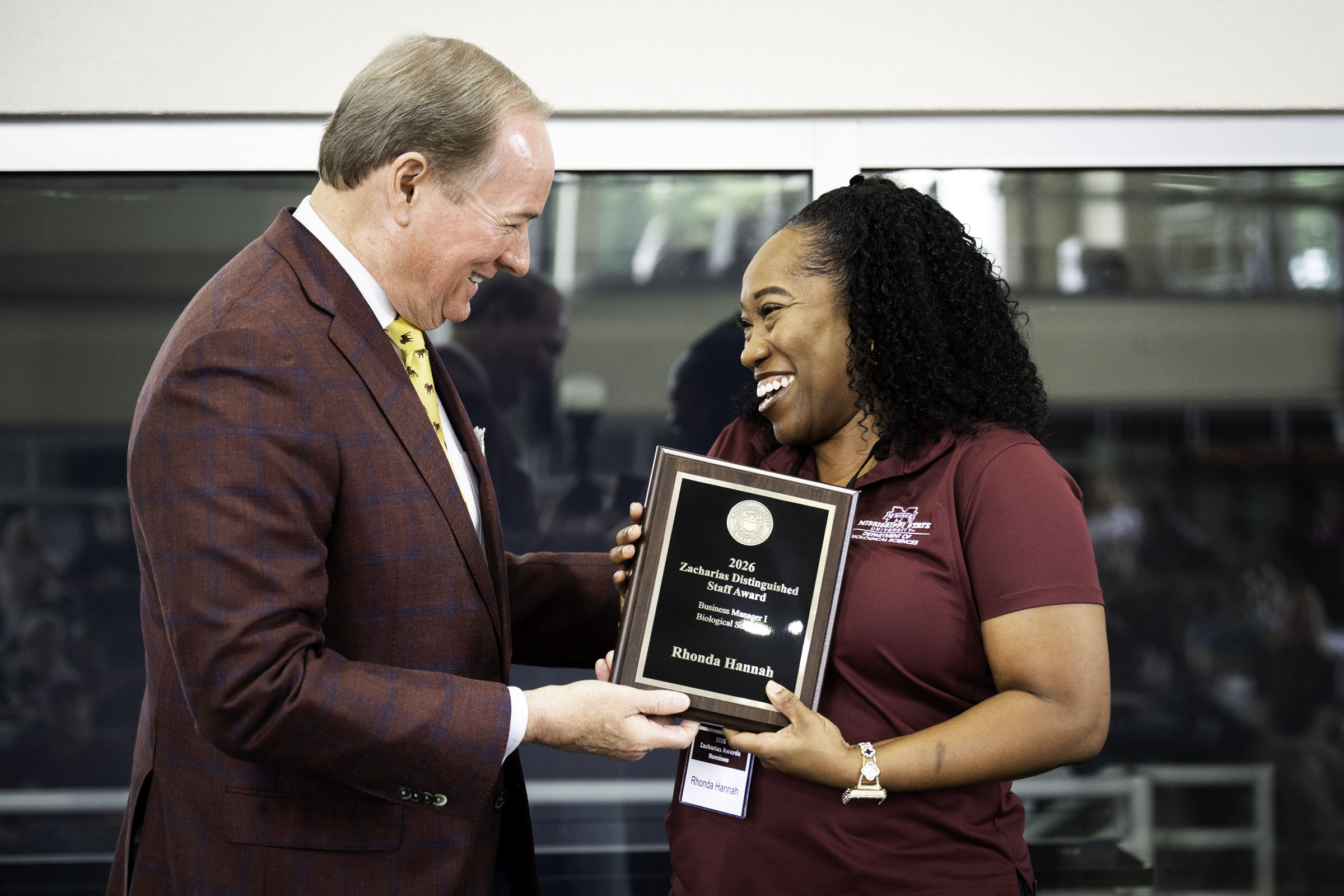 MSU President Dr. Mark Keenum happily hands off a shiny, engraved Zacharias Distinguished Staff Award, the highest honor a staff member can receive, to Rhonda Hannah, business manager I in MSU's Department of Biological Sciences at Staff Appreciation Day on Friday [May 22] afternoon. Presented annually at the event, the prestigious award recognizes 12 staff members whose dedication, leadership, and service have made a lasting impact across the university community. 