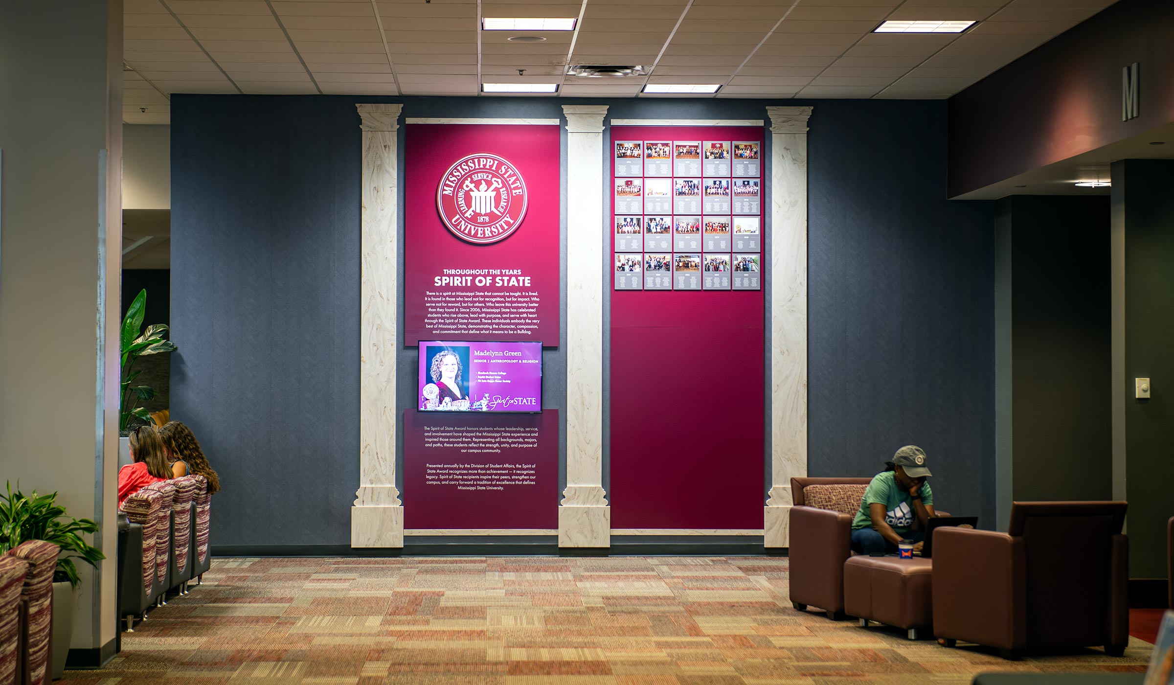 A new decorative wall in the Union displays group photos of Spirit of State award winners. 