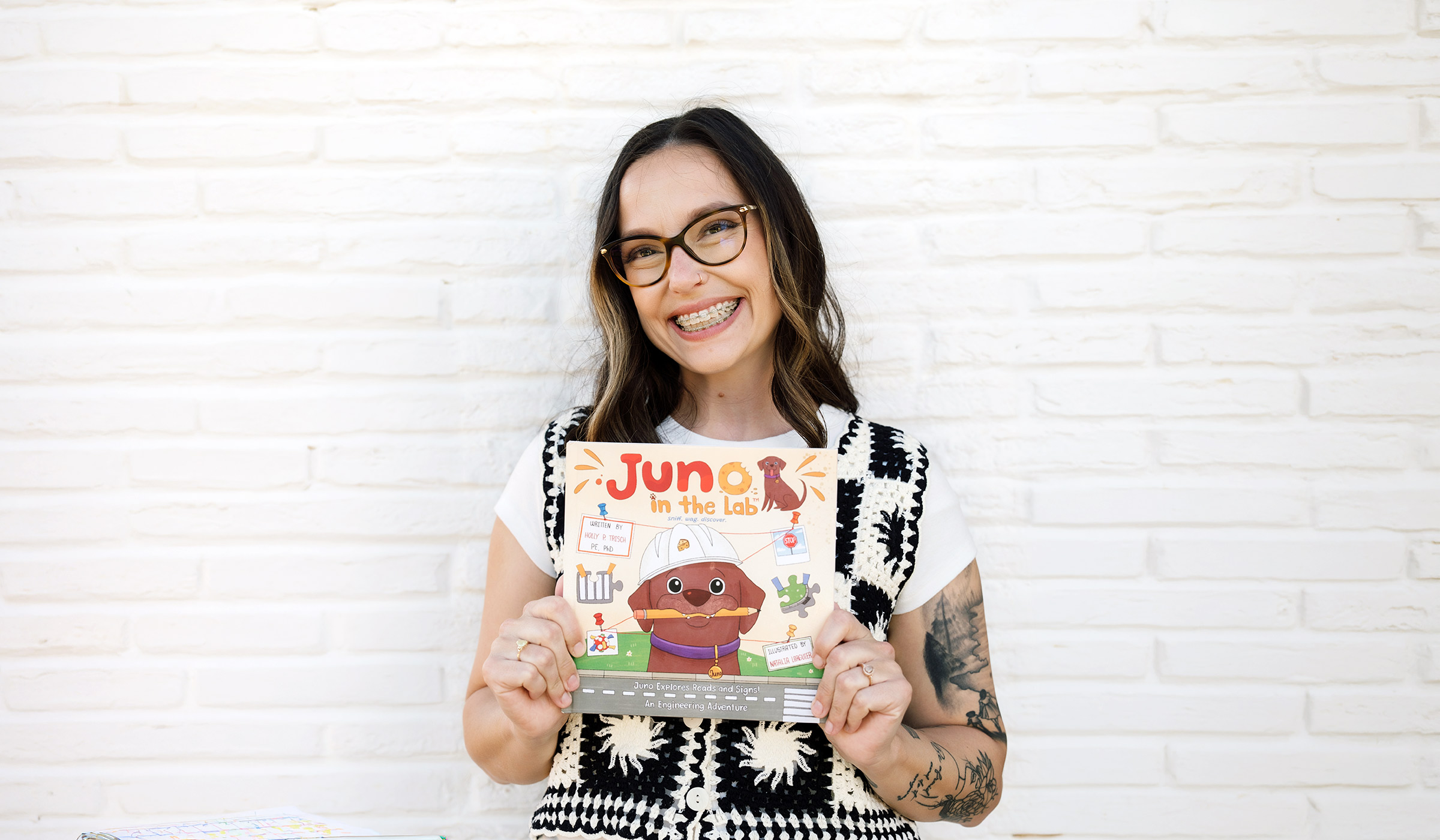 Portrait of Holly Trisch holding her book “Juno in the Lab”