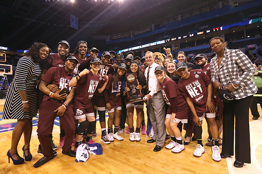 Members of the women&amp;#039;s basketball team pose with trophy after earning a trip to the Final Four.