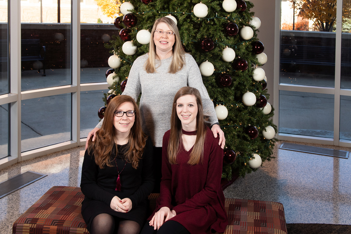 Courtney Blaylock, Paula and Lynn Carnaggio, pictured in front a Christmas tree in McCool Hall.