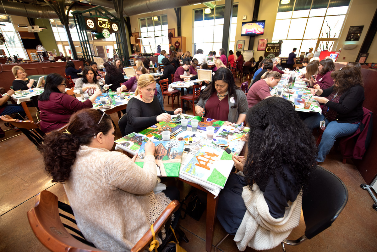 Female MSU staff members paint pictures of the Chapel in Barnes and Noble