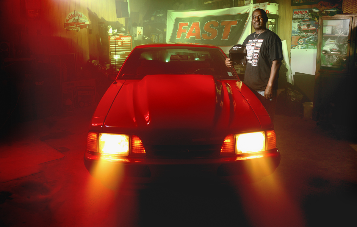 Larry Alexander poses next to his car.