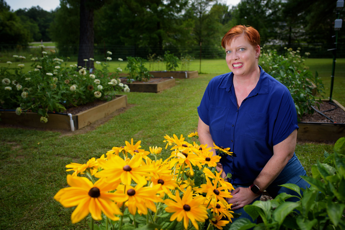 Christine Coker, pictured in a colorful garden.