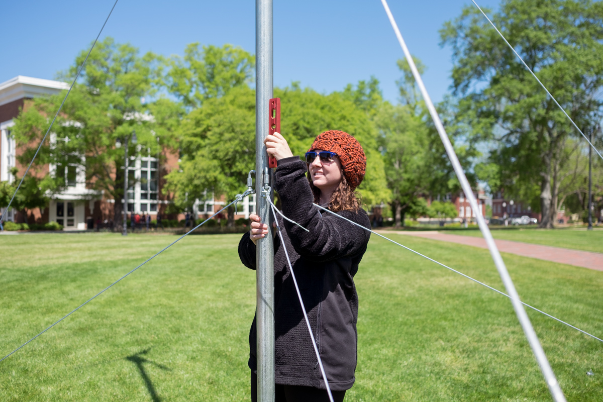 Civil Engineering student Diana Linder adjusts the windmill they set up on the Drill Field as part of the Earth Day Fair.