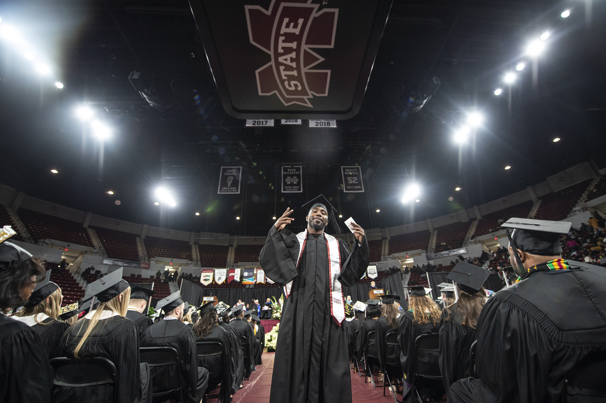 MSU Football Running Back Aeris Williams poses for the camera after crossing the stage during the 2018 Graduation Ceremony.