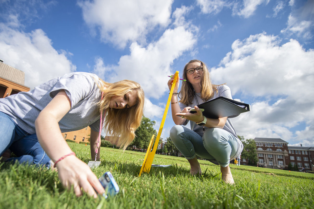 Global Teaching Project Participants Kimberly Bailey and Lilly Mayerhoff work at finding the height of a flag pole. 
