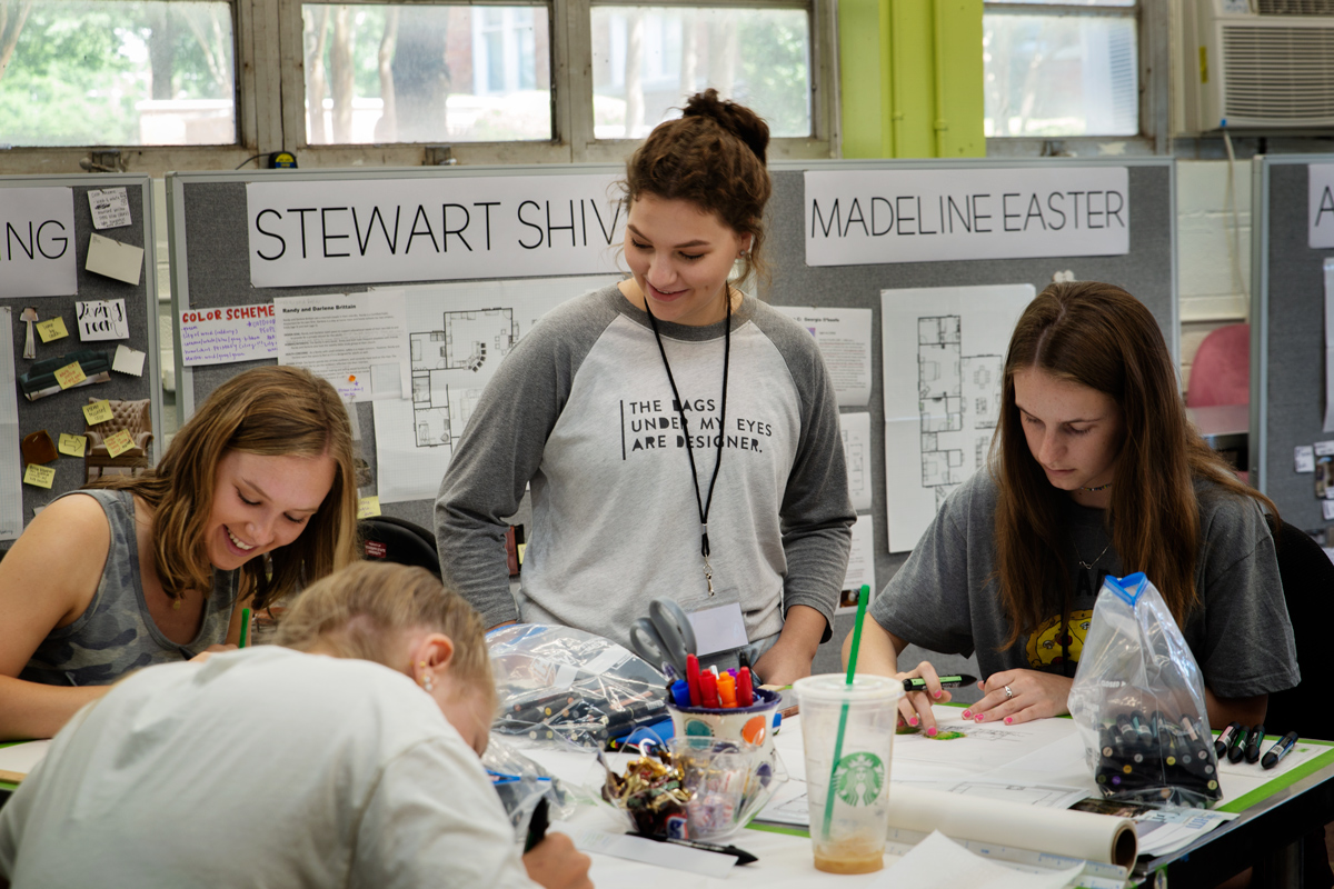 Nancy Strube and three incoming freshman sketching in an interior design studio on campus