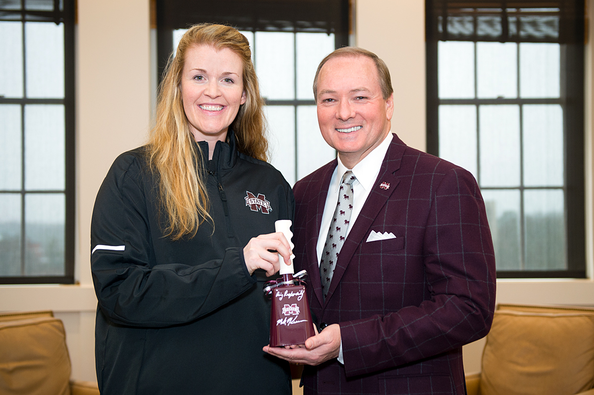 New volleyball coach, Julie Darty, is welcomed by President Keenum, with a cowbell.