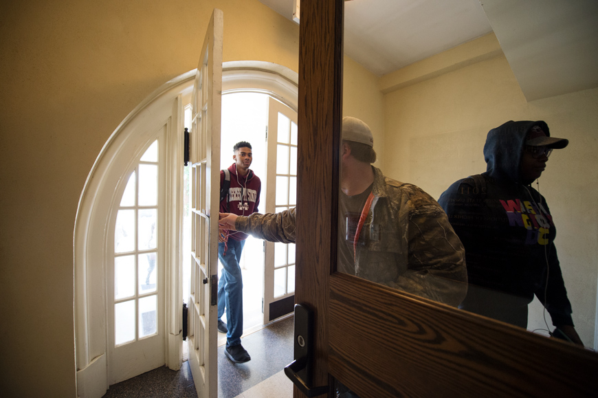 Students hold doors open for each other at entry to Harned Hall. (Photo by Megan Bean)