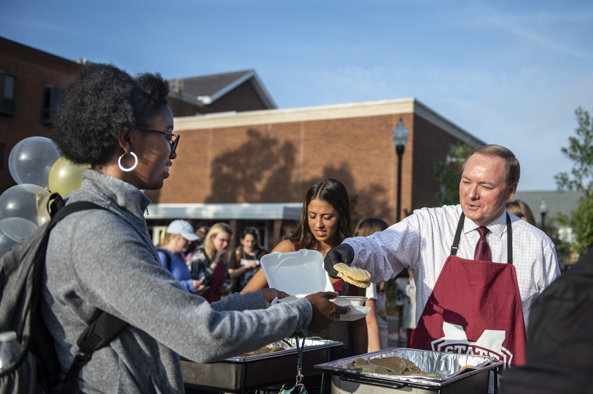 MSU President Dr. Mark Keenum serves pancakes to students outside of the Colvard Student Union for Pancakes on the Plaza.