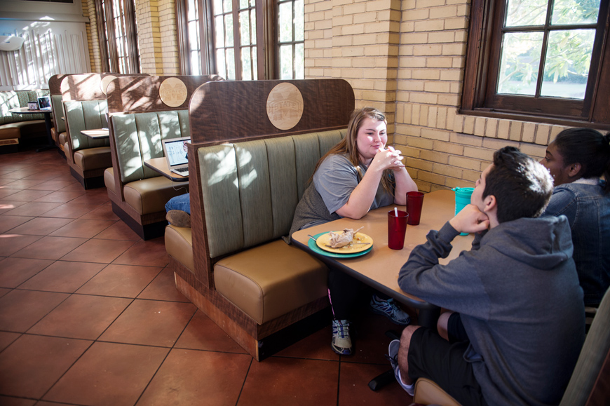 Students sit and talk while eating breakfast in a booth at Perry Cafeteria