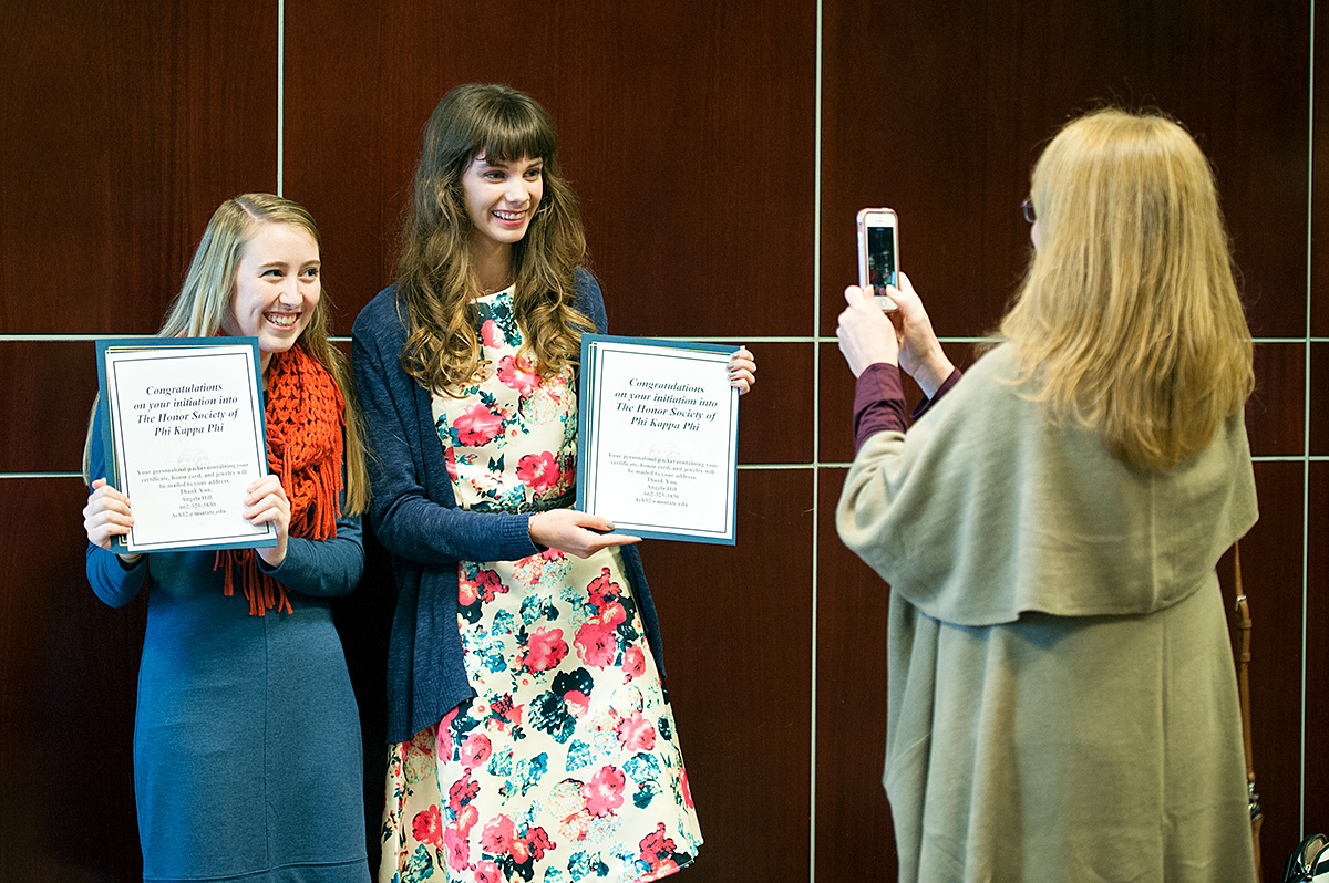 Phi Kappa Phi inductees celebrate with a photo.